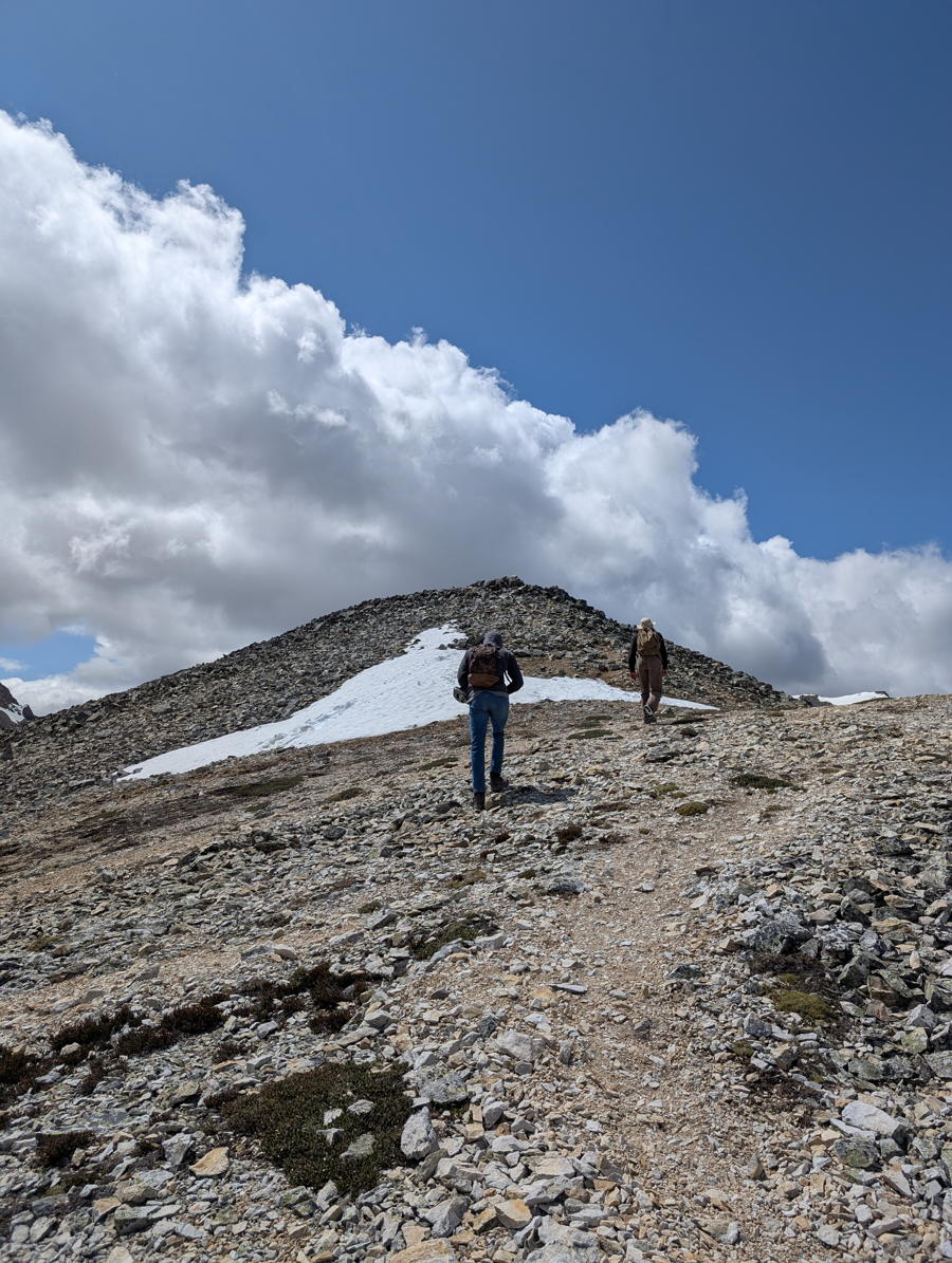 Two hikers travel along an alpine ridge