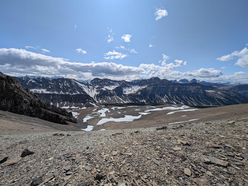 A picture looking down from an alpine saddle to a lake.