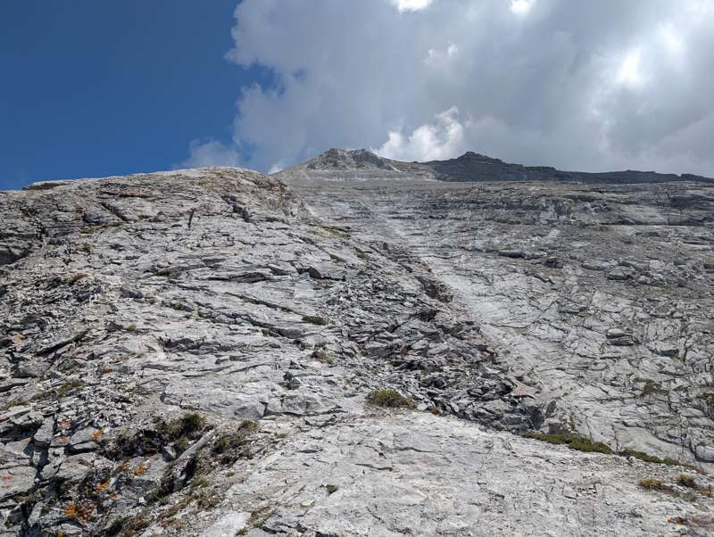 Views to a mountain's summit from its upper slopes.
